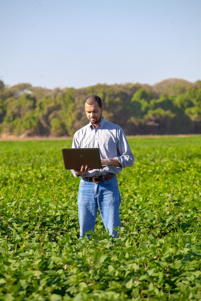Man Holding computer in a field.